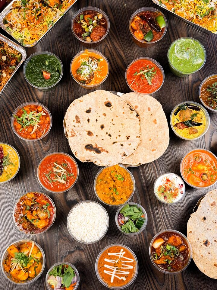 A spread of Spice Village tiffin curries, breads and rice